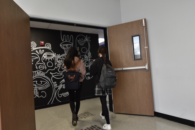 Two female students walk past a mural at SET High.