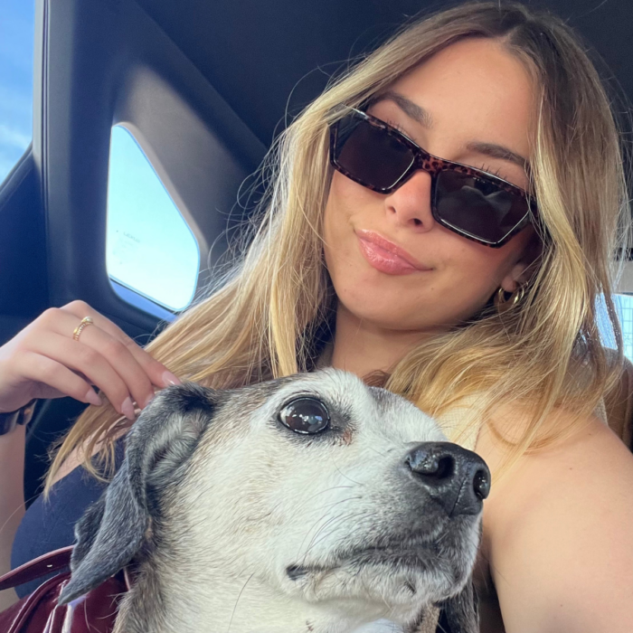 SET High graduate Gigi Mantovani sits in a car with a dog on their lap.